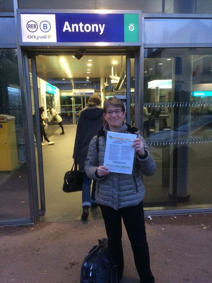Une militante du collectif montre un tract d’Antony Terre Citoyenne devant la gare RER B d’Antony.